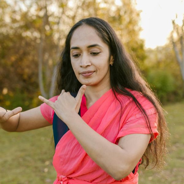 Person standing in a balanced tree yoga pose against a serene, dark background.